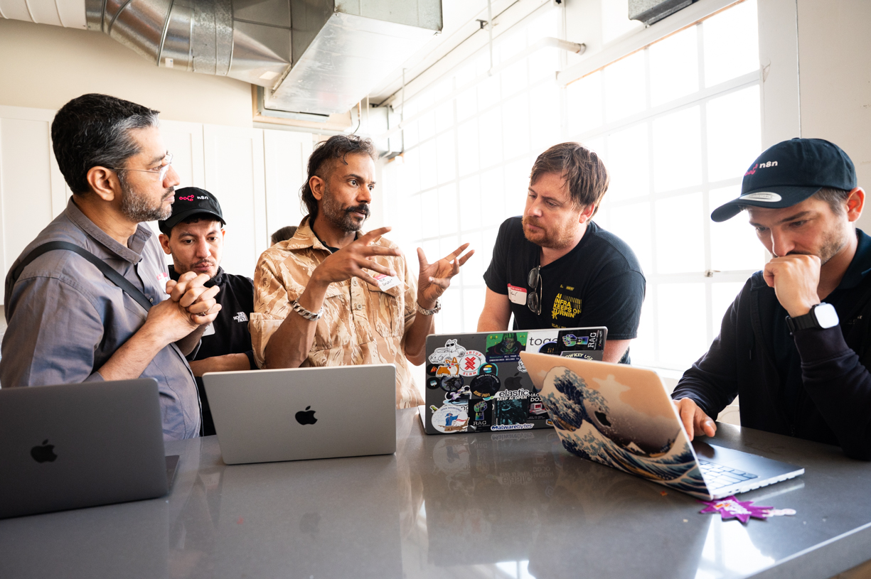 Hackathon participants collaborating around a laptop